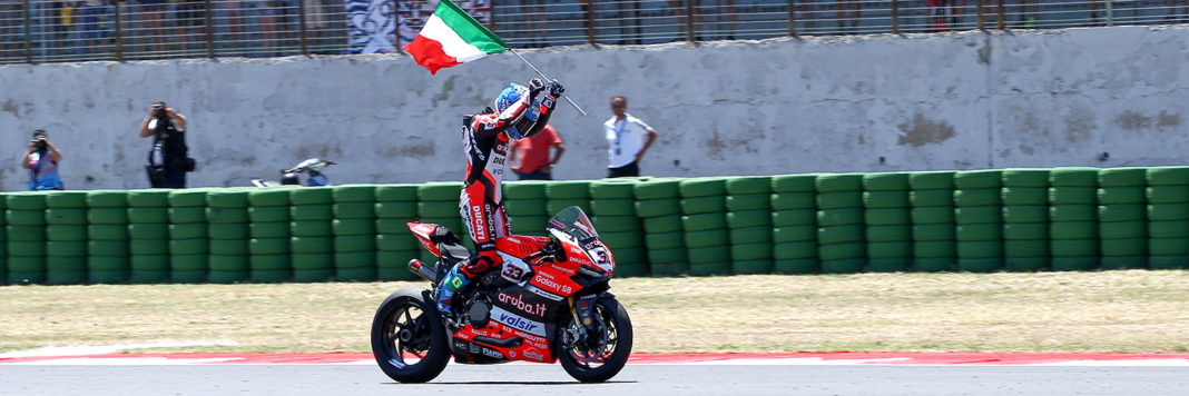 Marco Melandri esulta, sventolando il tricolore, per la vittoria in gara 2